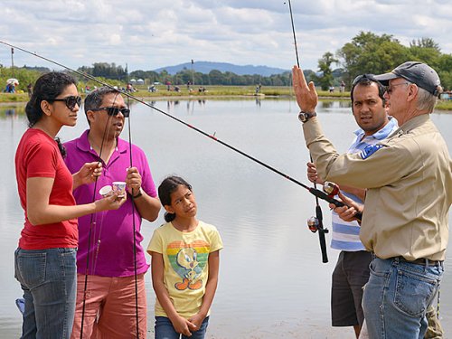ODFW volunteer angling instructor Jack Morby goes over the basics of trout fishing with Sunil, Caroline, Phillip, and Nihal Nazareth during the 2014 free family fishing event at Sheridan Pond. Family fishing returns to Sheridan Pond on Saturday, May 23, 2015. (Photo by Rick Swart/ODFW)