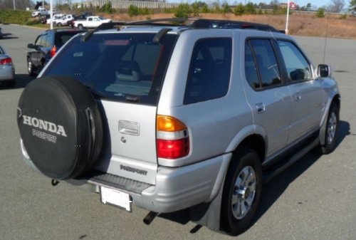 silver 1999 Honda Passport with a spare tire on the back