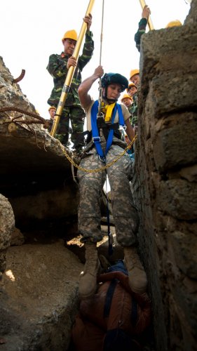 taff Sgt. Elizabeth Christner, of the 224th Engineer Company, Oregon Army National Guard, demonstrates the use of a tripod designed for hoisting victims from deep holes to a team of engineers from 249th Engineer Brigade, Vietnam People's Army