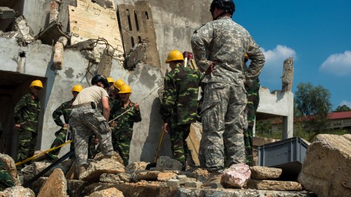 Staff Sgt. Elizabeth Christner (left) and Sgt. 1st Class Casey Bayes (right), of the 224th Engineer Company, Oregon Army National Guard, instruct a team of engineers from 249th Engineer Brigade, Vietnam People's Army, in the use of a tripod for hoisting victims out of rubble and deep holes